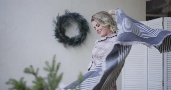 Attractive Young Woman Wraps Herself in a Warm Plaid in Slow Motion, Cozy Home Atmosphere, Warm