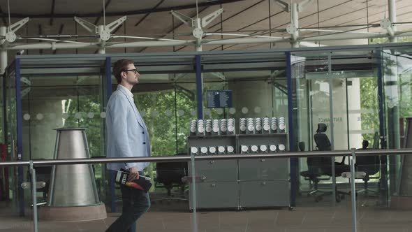 Side View of a Thoughtful Businessman in a Suit Walking in His Office