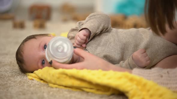 Cute Tiny Child Drinking Milk Formula From Bottle, Vitamin Complex for Babies