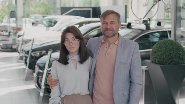 Portrait of Smartly Dressed Couple in Car Dealership