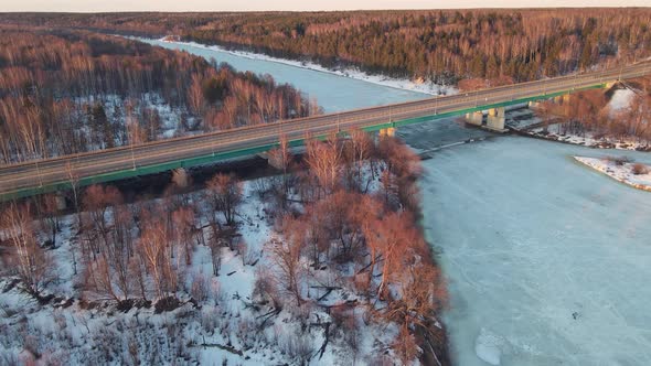 Majestic Winter Landscape with a Road Bridge at Sunset Aerial View