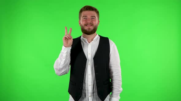 Man Shows Two Fingers Victory Gesture. Green Screen