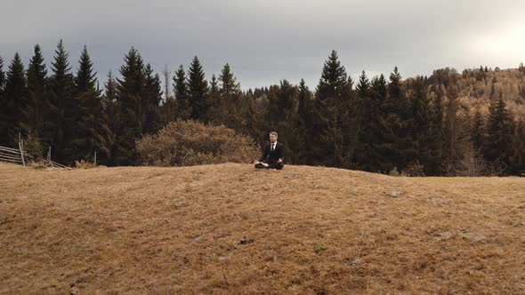 Business Man Relax on Mountain Top Aerial