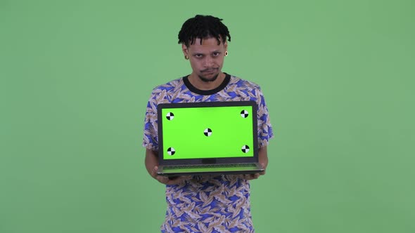 Stressed Young African Man Showing Laptop