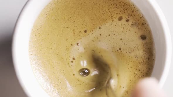 Vertical Video of Slow Motion View of Stirring Creamy Cup of Coffee