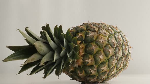 Fresh Ananas comosus on white slow tilt 4K 2160p 30fps UltraHD  footage - Exotic pineapple fruit lai