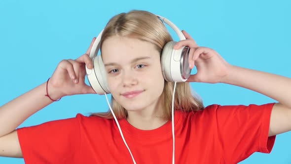 Close-up Blonde Girl Listening To Music in Big White Headphones. Slow Motion