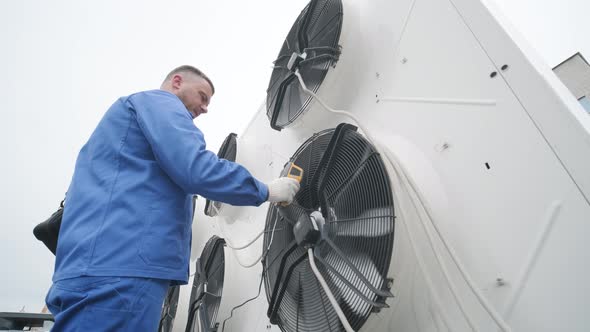 Technician uses a thermal imaging infrared thermometer to check the condensing