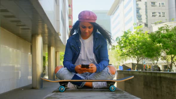 Female dancer with skateboard using mobile phone in the city 4k