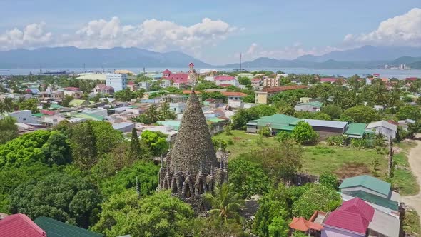 Coral Buddhist Temple in City Against Sea Hills and Blue Sky