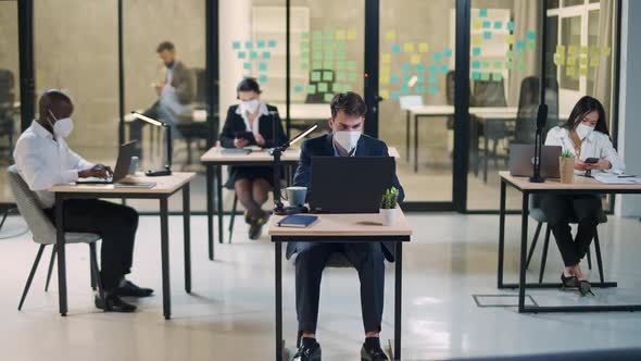 Modern International Office Office Workers and Managers in Medical Masks Working at Computers