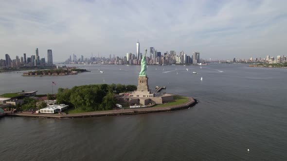 Aerial view passing the Statue of Liberty, towards the Lower Manhattan skyline, in NYC, USA