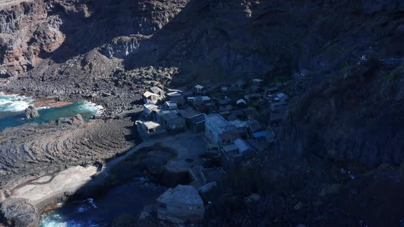 Aerial dolly tilt down over  old village surrounded by solidified lava