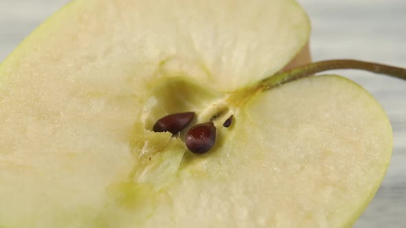 Green apple with seeds, cut in half.