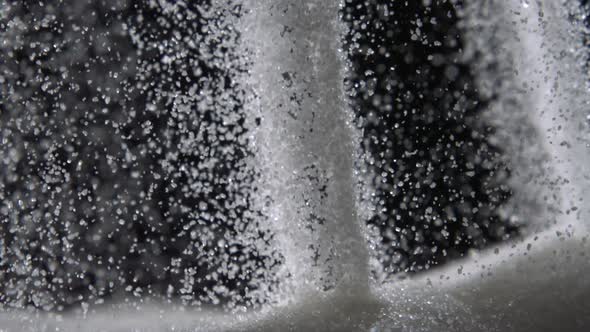 Pouring sugar on black background, Slow Motion alt