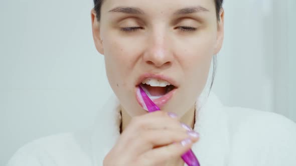 Beautiful Woman Brushing Her Teeth on White Background