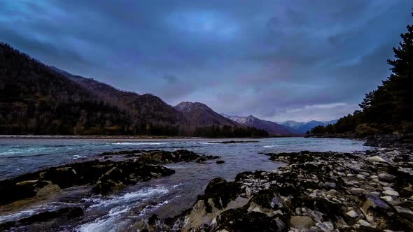 Time Lapse Shot of a River Near Mountain Forest. Huge Rocks and Fast Clouds Movenings.