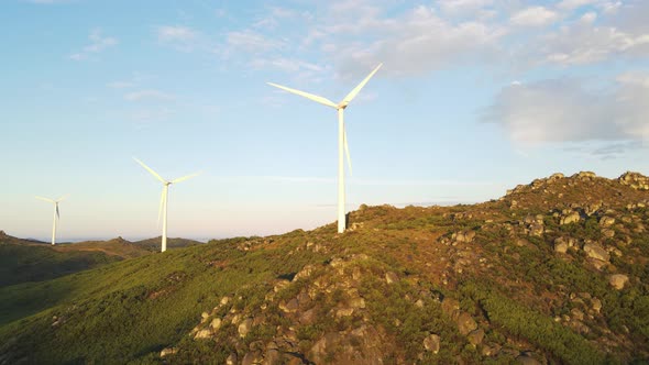 Wind turbines farm ontop of  mountain of Caramulo at sunrise, Portugal. Aerial circling