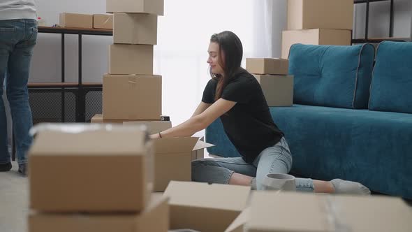 Beautiful Girl Puts Her Clothes in Cardboard Boxes for the Move