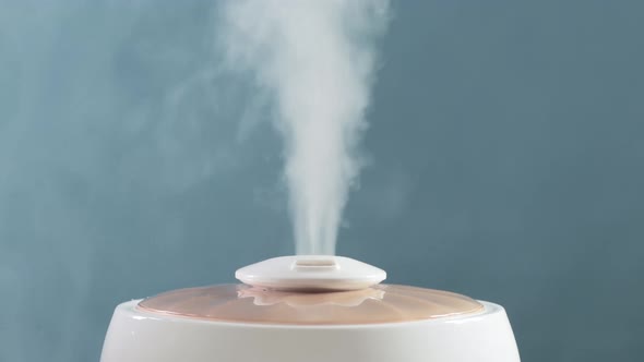 White Steam on a Blue Background From a Humidifier