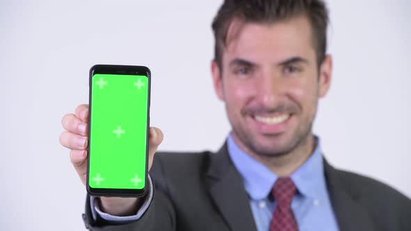 Young Happy Hispanic Businessman Showing Phone