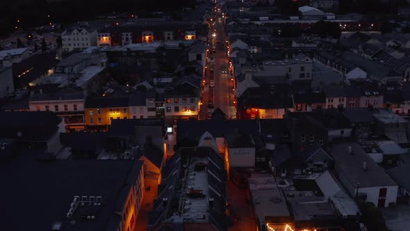 Forwards Fly Above Illuminated Street in Town After Sunset