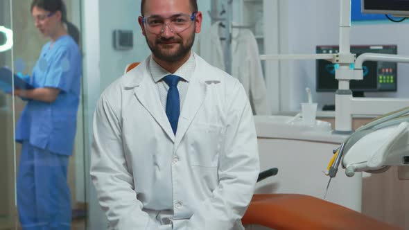 Stomatologist Smiling at Camera Sitting in Dental Office