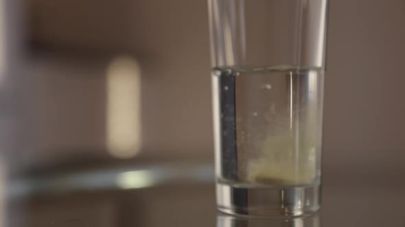 Effervescent Tablet Dissolves in a Transparent Glass of Water Closeup