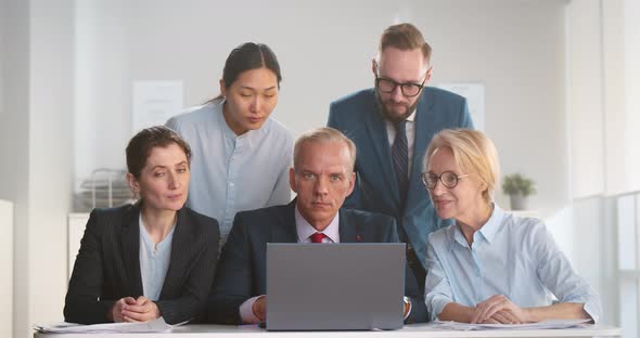 Portrait of Corporate Business Team Working on Laptop and Smiling at Camera