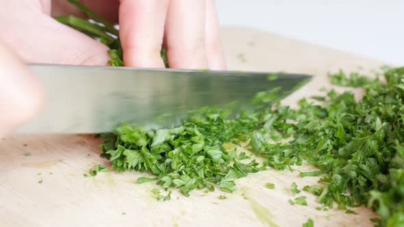 Cutting green organic parsley plant on smaller pieces with knife 4K 3840X2160 UltraHD  footage - Pet