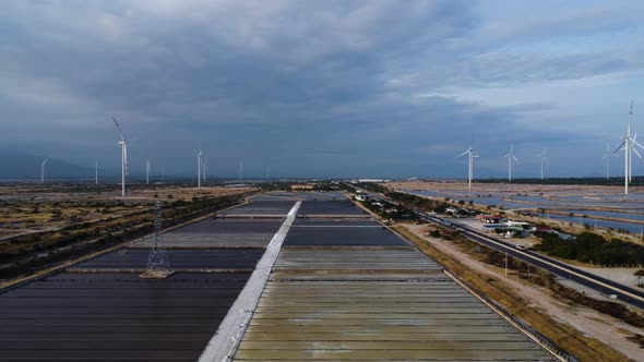 Birds eye view of salt fields spread across windmill farm in Phan Rang. Vietnam. Aerial.