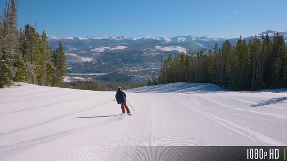 Following a Skier Down an Empty Ski Trail Freshly Groomed at a Ski Resort