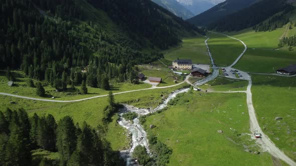 Drone aerial view from Lüsens valley with the old Lüsens Inn and the high mountains of Austria in th