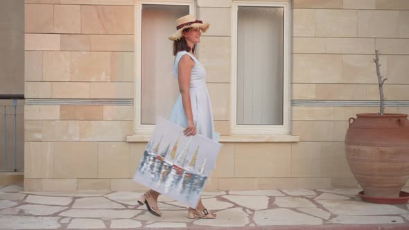 Side View of Happy Proud Woman Walking with Pictures in Slow Motion Smiling
