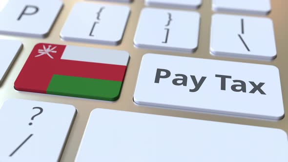 PAY TAX Text and Flag of Oman on the Computer Keyboard