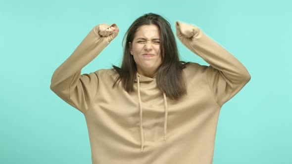 Annoyed Young Woman in Beige Hoodie Shaking Hands and Looking Angry Staring with Rage and Distress