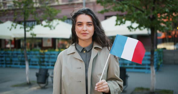 Slow Motion Portrait of Cute French Girl Standing Outdoors with Flag of France