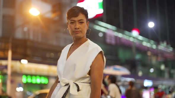 4K Confidence Asian lgbtq guy wearing woman clothes walking down city street at night