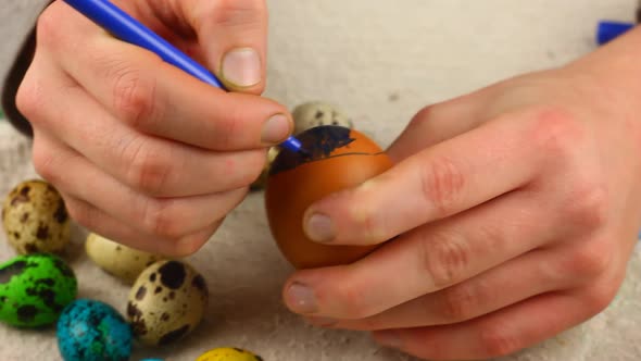 a Child of Caucasian Ethnicity Paints an Easter Egg with a Felttip Pen