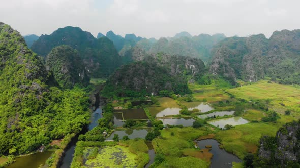 Aerial: North Vietnam karst landscape at sunset, drone view of Ninh Binh region, tourist destination