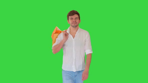 Handsome Man in Casual Clothes Walking with Shopping Bags Looking at Camera on a Green Screen