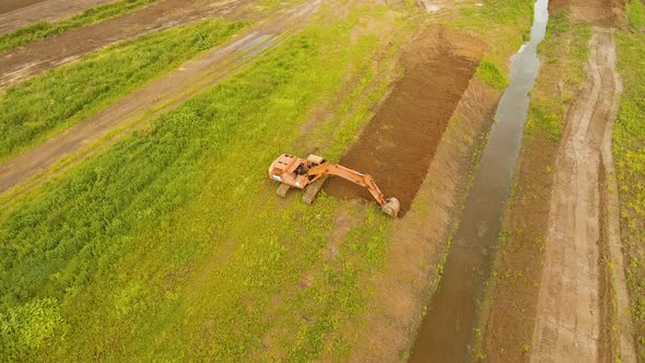 Excavator Digging a Trench in the field.Aerial Video.