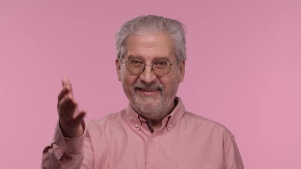 Portrait of an Elderly Man with Glasses Waving Hand and Showing Gesture Come Here