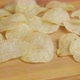 White man eats chips. A man's hand chooses chips from a wooden plate. Close-up - VideoHive Item for Sale