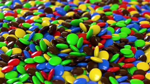 Round multicolored candies fall on the pile