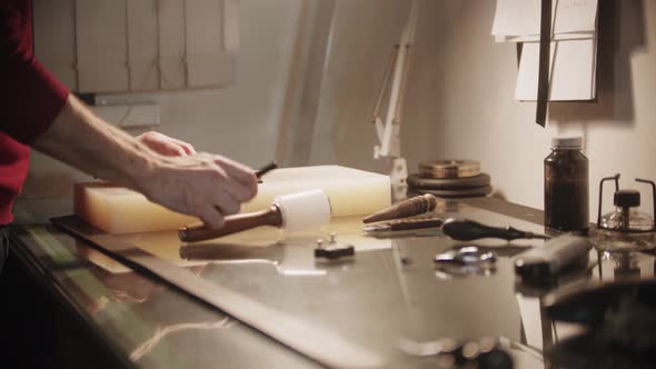 Tailor Makes Holes in a Small Piece of Leather