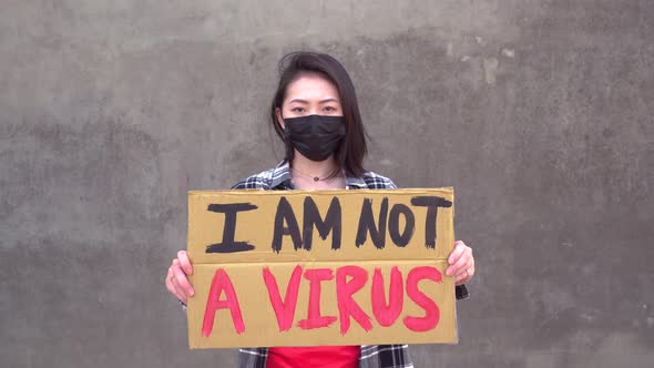 Asian woman with poster during protest against sexual harassment