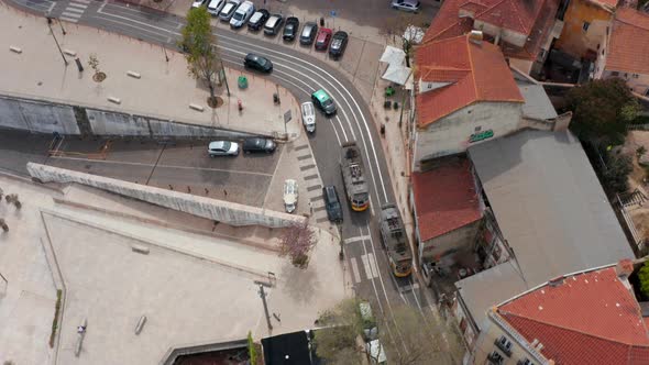 Two Tram Cars Passing By Each Other in Narrow Town Street