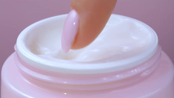 Woman Takes Finger Cream From a Pink Jar