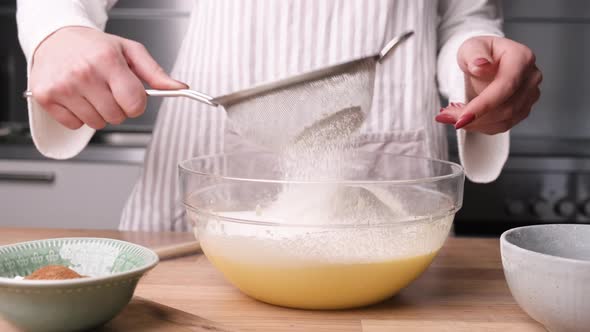 Female Hands Sift Flour into Bowl for Cake Batter. - Slider Left